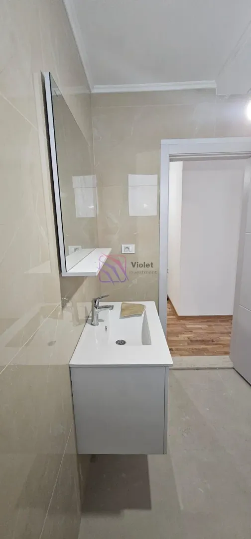 Kupatilo sa umivaonikom, ormarićem i ogledalom.