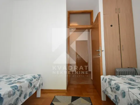 Bedroom with two single beds and a fitted wardrobe. - image 9