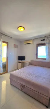 Bright bedroom with a double bed, TV, and terrace access. - image 13