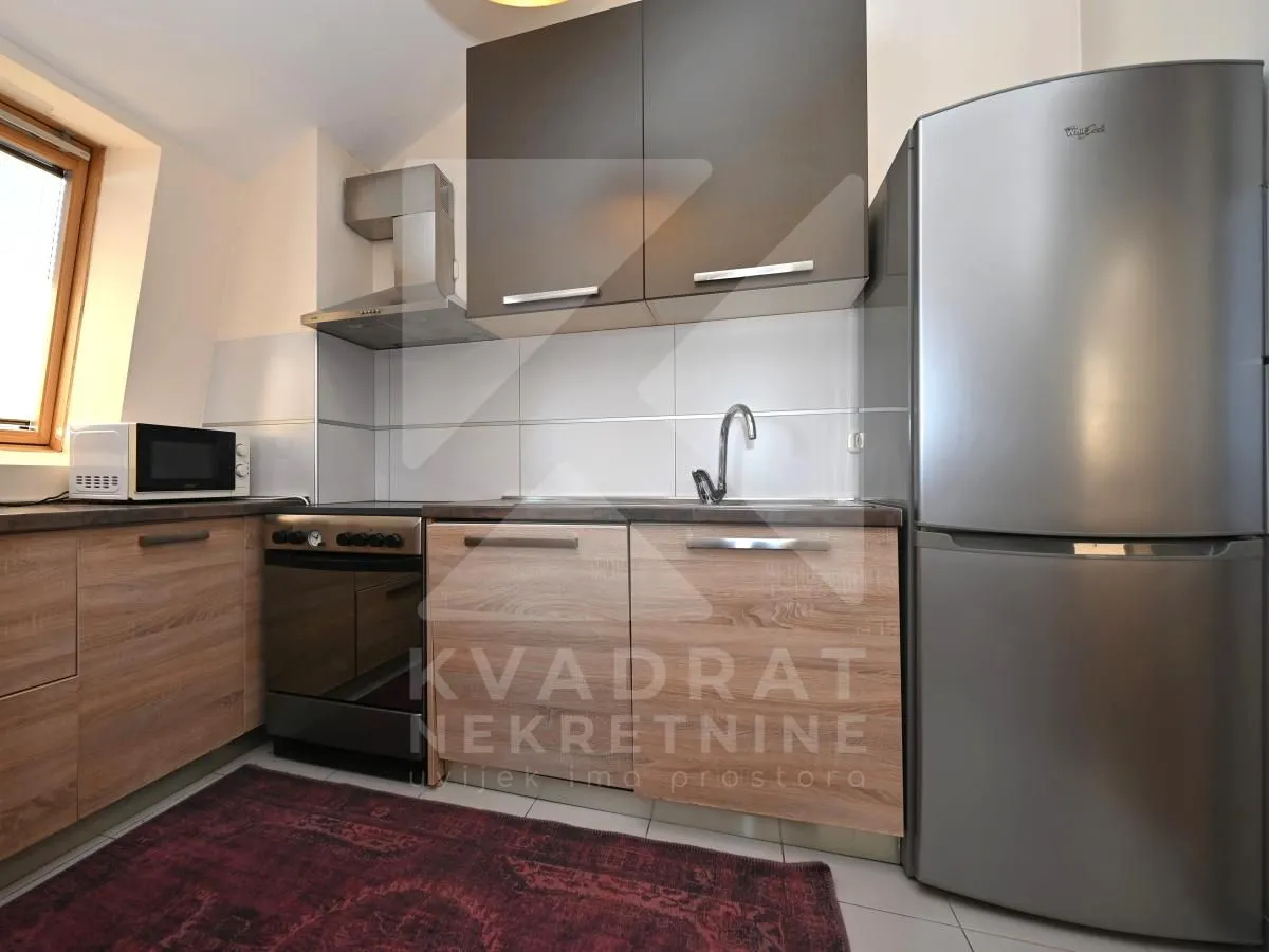 Small kitchen with wooden cabinets, a stove, and a refrigerator.
