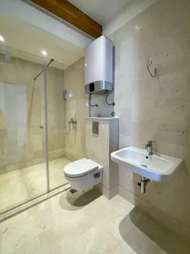 Kupatilo obloženo svijetlim pločicama sa tuš kabinom, WC šoljom, umivaonikom i bojlerom. - image 6