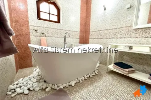 Bathroom with a freestanding bathtub and decorative pebbles on the floor. - image 17