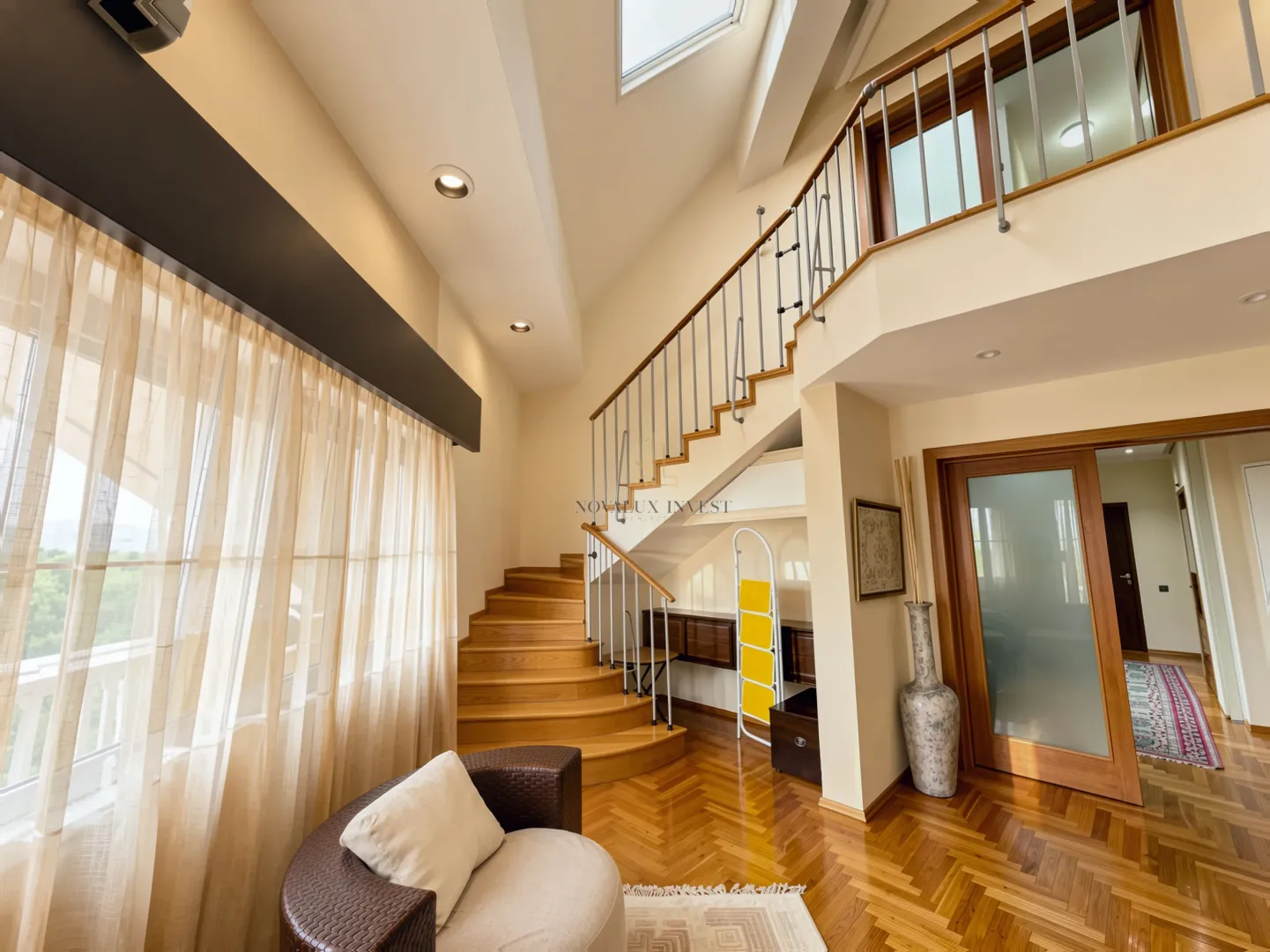 Spacious living room with a staircase and a gallery on the upper floor.