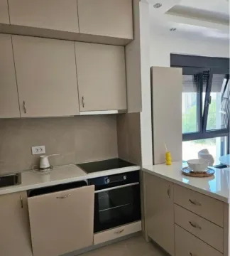 Modern kitchen with beige cabinets and built-in appliances. - image 3