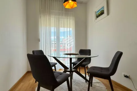 Dining area with a round table and chairs by the window. - image 4
