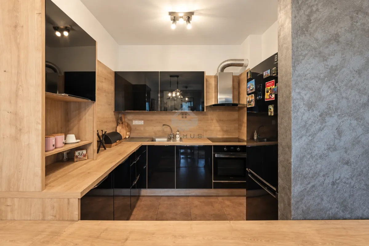 Modern kitchen with wooden elements and built-in appliances.