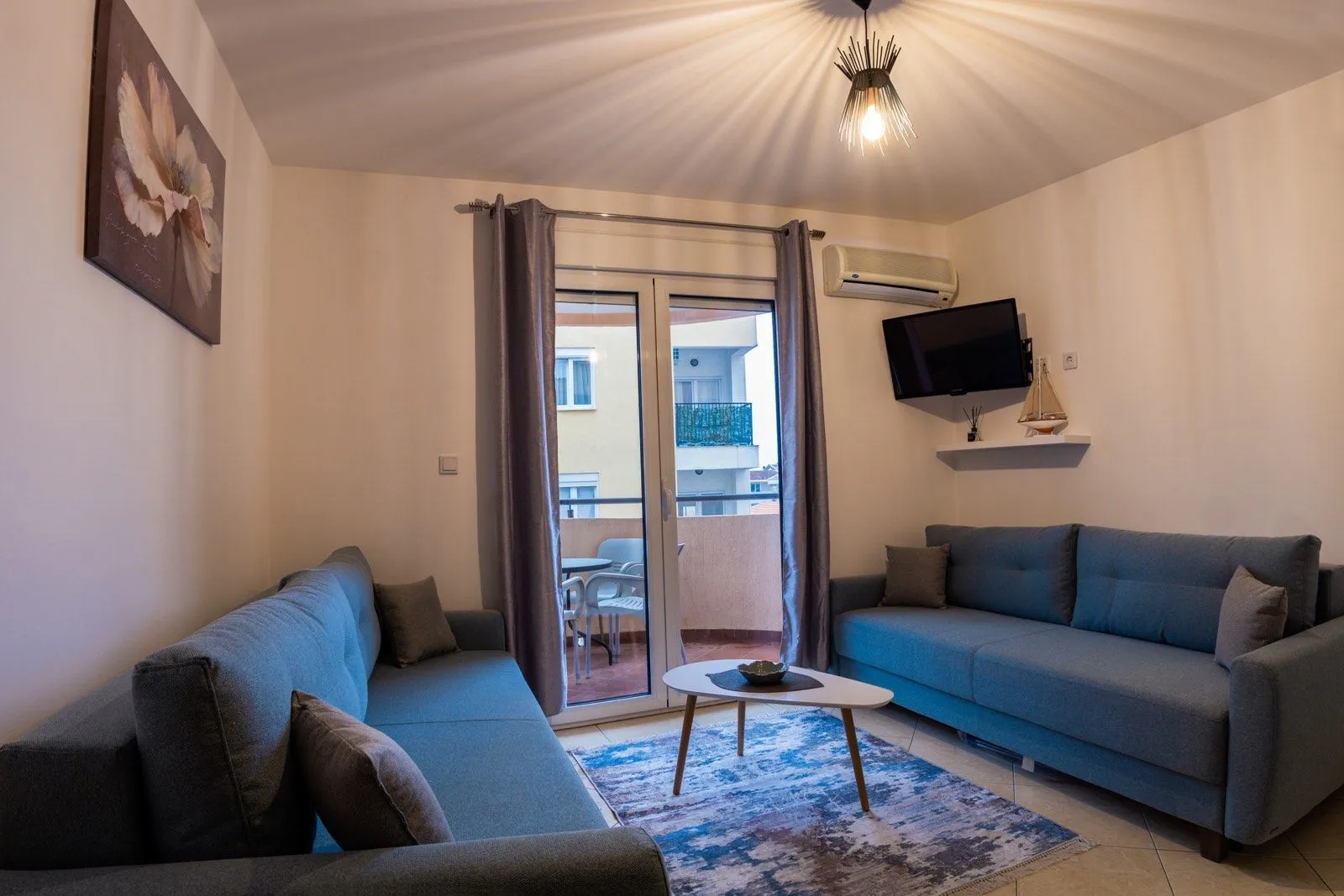 Living room with a sofa set, coffee table, and access to the terrace.
