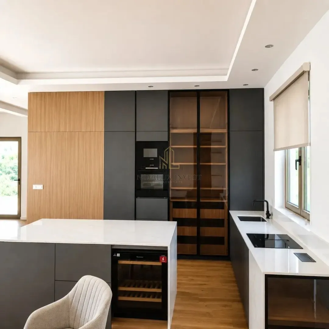 Modern kitchen with an island, built-in cabinetry, and white countertops.
