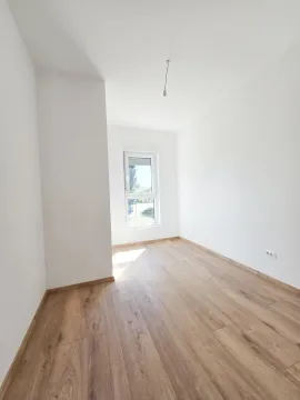 Prazna soba sa bijelim zidovima i drvenim podom. - image 3