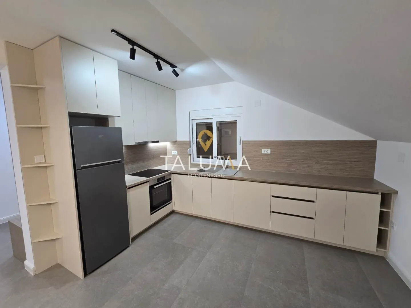 Modern kitchen with built-in appliances and a refrigerator in the attic.
