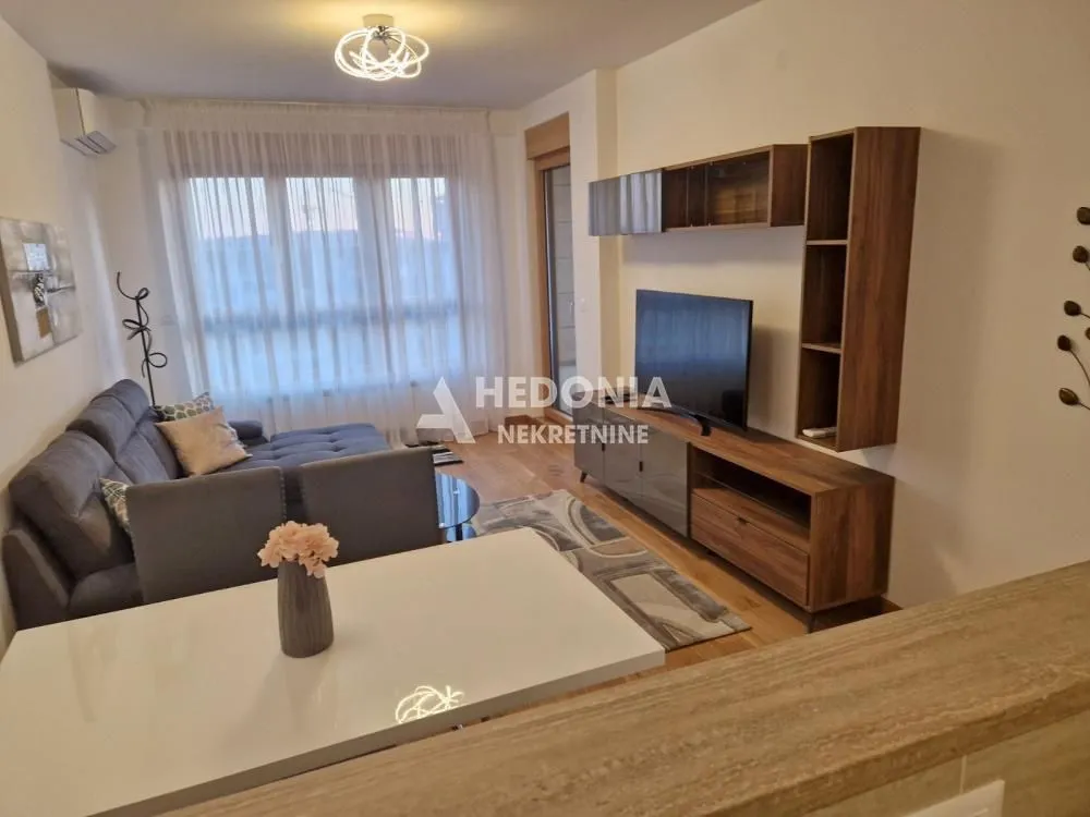 Living room with sofa, TV and dining table.