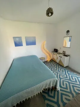 Manja spavaća soba sa bračnim krevetom, plavim detaljima i komodom. - image 3