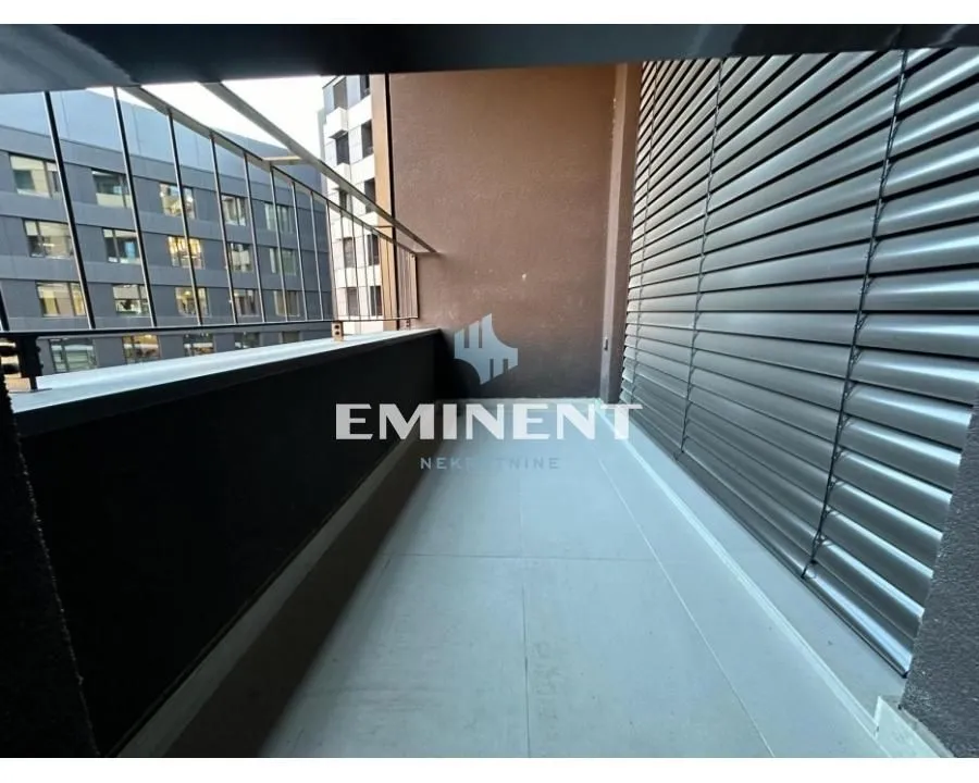 Covered terrace with a metal railing and a view of neighboring buildings.