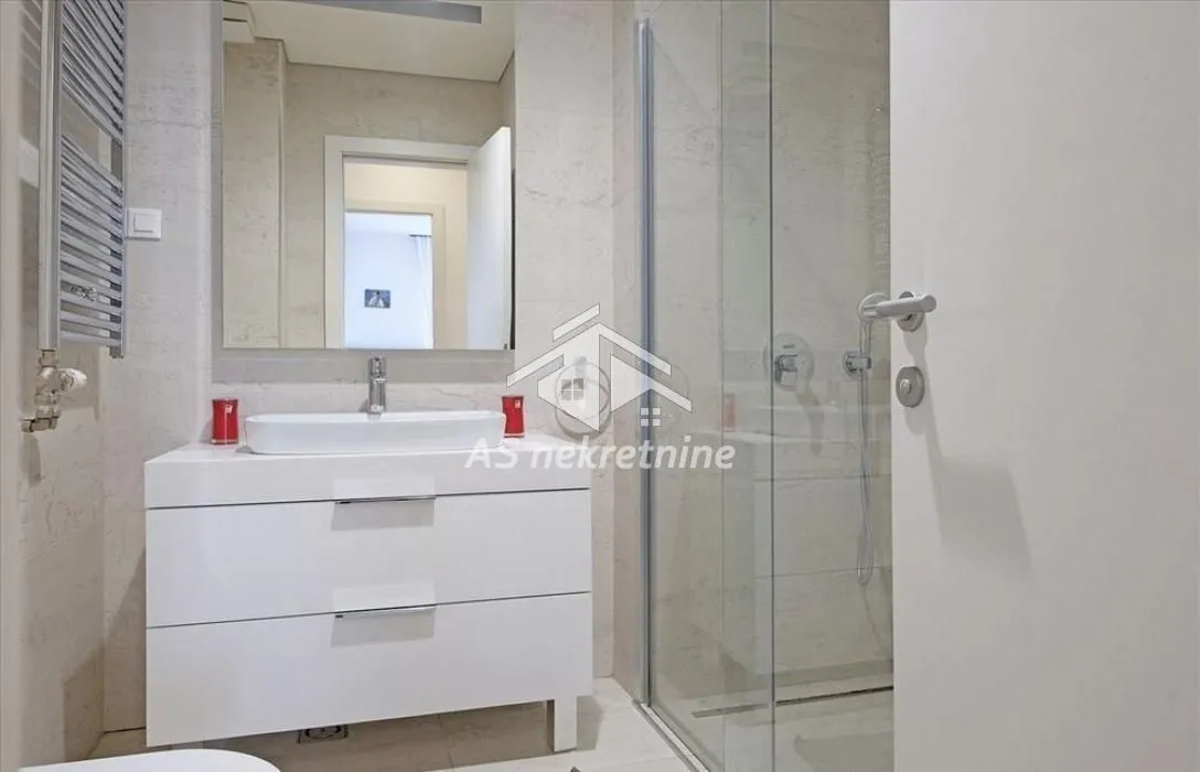 Modernly equipped bathroom with a washbasin and a shower cabin.
