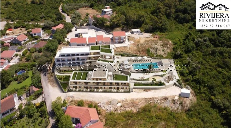 Pogled iz vazduha na kompleks zgrada sa bazenom i okruženjem.