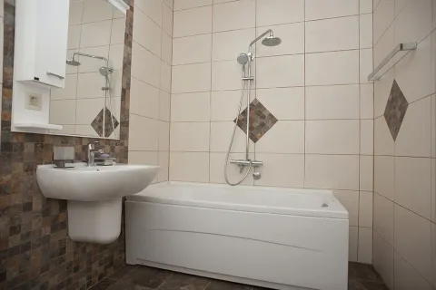 Svijetlo kupatilo sa kadom, umivaonikom i ukrasnim pločicama. - image 11