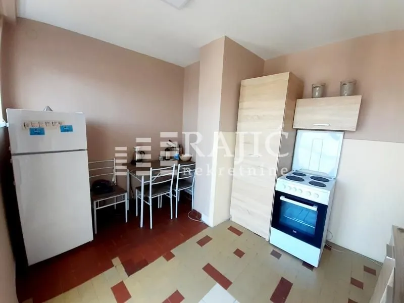 Smaller kitchen with a dining table and basic kitchen units.