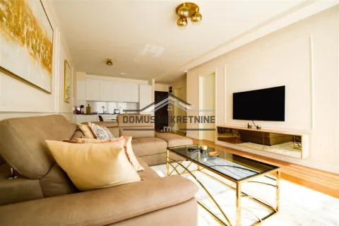 Living room with a sectional sofa, coffee table, and wall-mounted TV. - image 3
