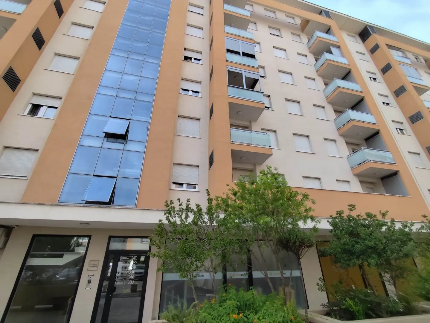 View of the exterior of a residential building with balconies and entrance.