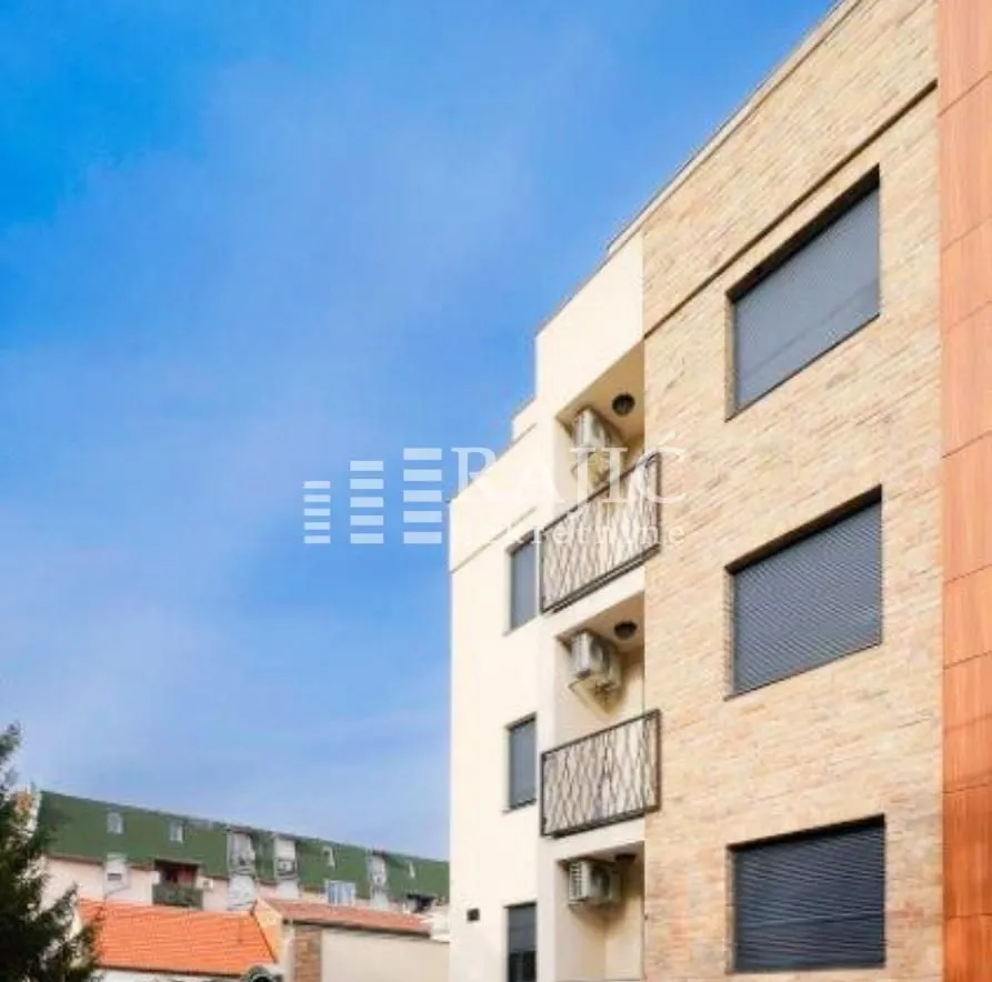 Exterior of a modern residential building with balconies and beige facade.