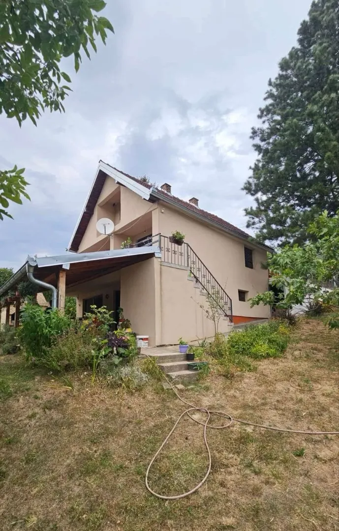 Spoljašnji izgled kuće sa dvorištem i spoljnim stepeništem.