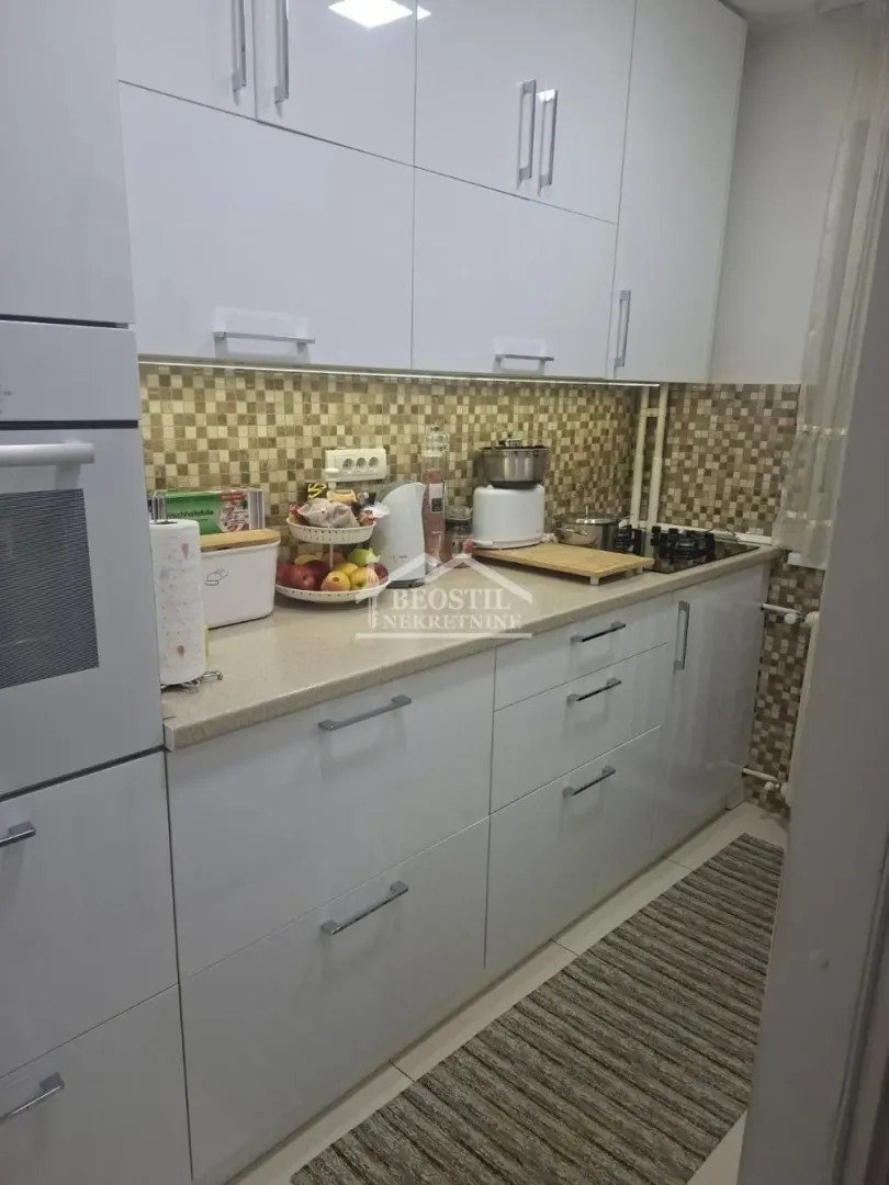 Small white kitchen with a countertop and built-in appliances.