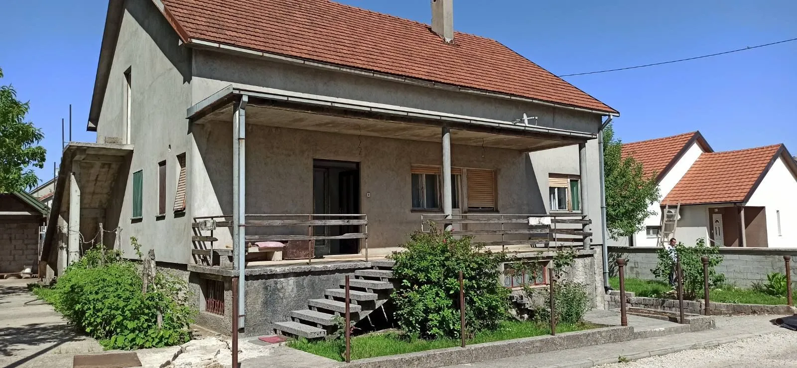 Exterior view of the house with yard and terrace.