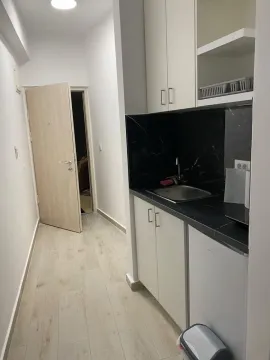 Manja kuhinja u hodniku sa crnom radnom pločom i bijelim elementima. - image 6