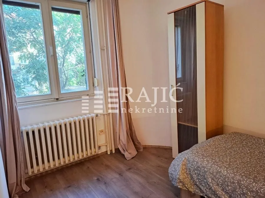 Furnished bedroom with a bed, wardrobe, and a window.