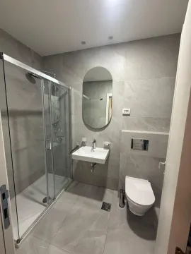 Moderno kupatilo sa tuš kabinom, ogledalom i sivim pločicama. - image 12