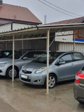 Natkriveni parking prostor sa parkiranim automobilima. - image 3