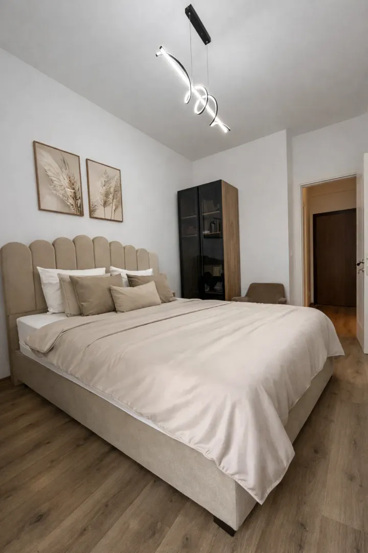 Moderna spavaća soba sa velikim bračnim krevetom, garderoberom i osvjetljenjem.