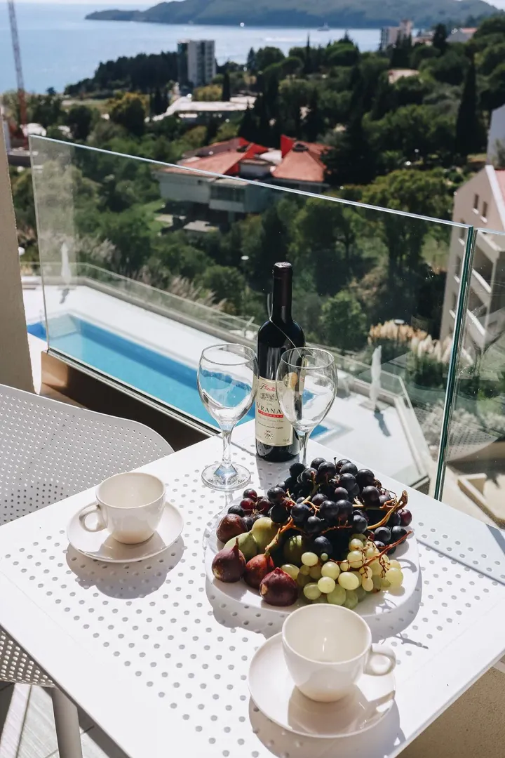 Terrace view of the sea and swimming pool with a set table for two.