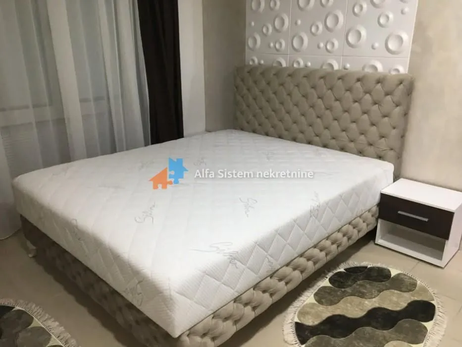 Furnished bedroom with a double bed and a nightstand.