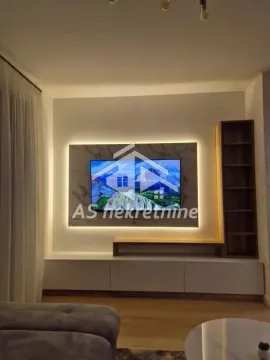Living room with a modern TV unit and ambient lighting. - image 5
