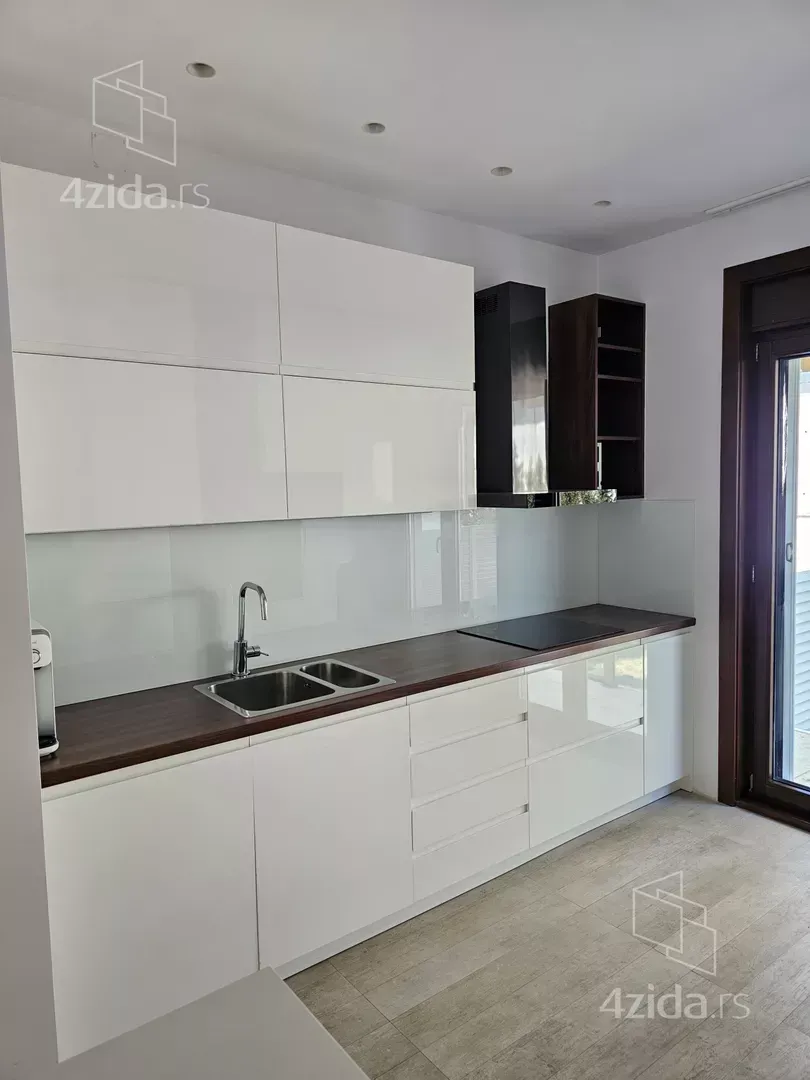 Modern kitchen with white units and dark countertops.