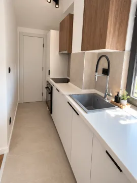 Moderna kuhinja sa bijelim elementima, drvenim gornjim ormarićima i sivom sudoperom. - image 4