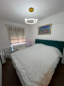 Furnished bedroom with a double bed, baby crib, and a modern chandelier. - image 8