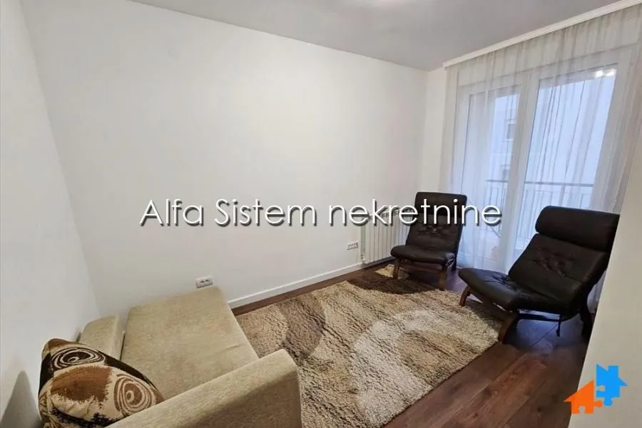 Smaller living room with a sofa, armchairs, and a rug.