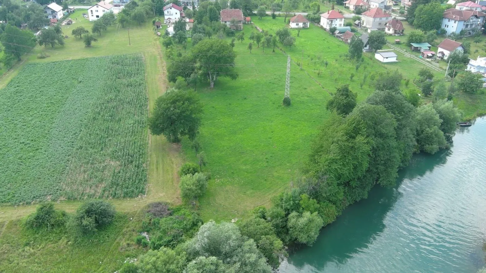 Pogled iz vazduha na zemljište sa zelenilom i rijekom.