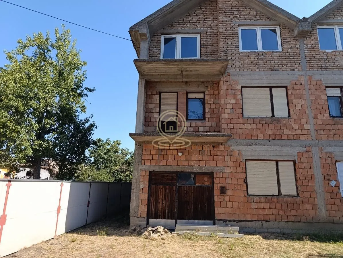 Pogled na spoljašnjost kuće u izgradnji sa ciglom i balkonom.