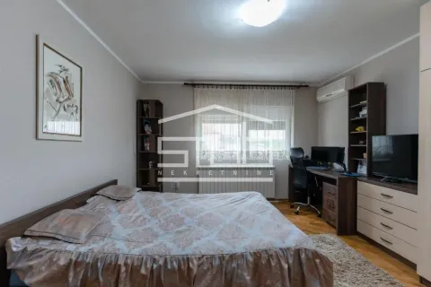 Furnished bedroom with a double bed, desk, and television. - image 3