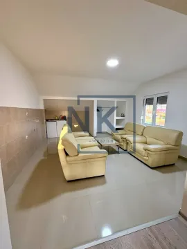 Living room with seating furniture and a small kitchen in the background. - image 4