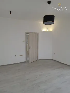 Empty room with laminate flooring and a hanging lamp. - image 6