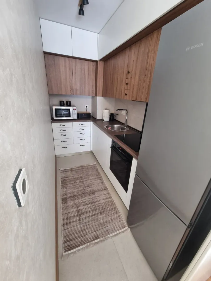 Tidy and modern narrow kitchen with built-in appliances.