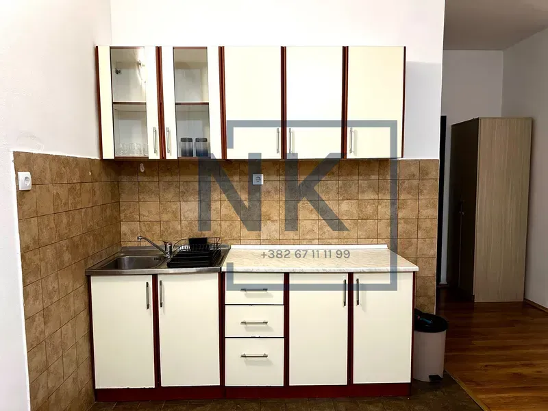 Small kitchen with white cabinets and ceramic wall tiles.