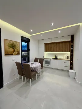 Modern kitchen with an integrated dining table and chairs. - image 2
