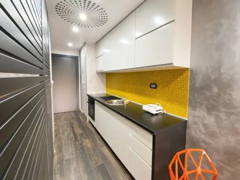 Small kitchen with white cabinets and a yellow mosaic backsplash. - image 6