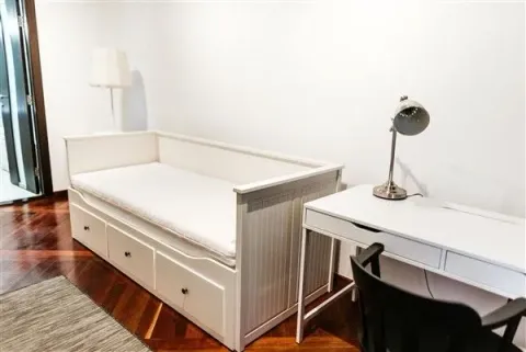 Bright room with a white bed and a study desk. - image 14