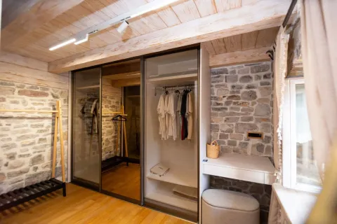 Modern bedroom with built-in wardrobe, wooden ceiling and exposed stone wall. - image 18